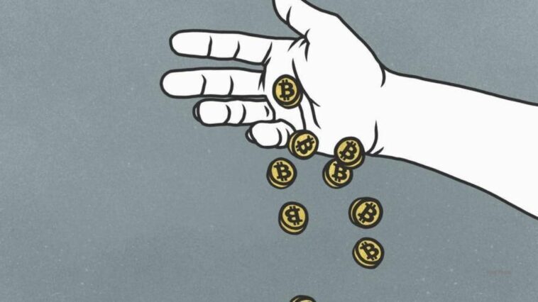 a hand dropping a handful of coins representing bitcoin tokens