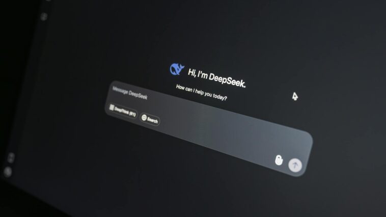 Close-up of DeepSeek AI chat interface on a laptop screen in low light.