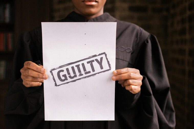 A judge in a courtroom holding a paper with a guilty verdict, symbolizing law and justice.