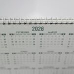 Close-up of a 2026 spiral-bound desk calendar with months in Portuguese.
