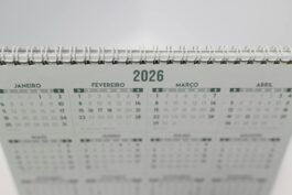 Close-up of a 2026 spiral-bound desk calendar with months in Portuguese.