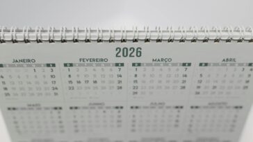Close-up of a 2026 spiral-bound desk calendar with months in Portuguese.