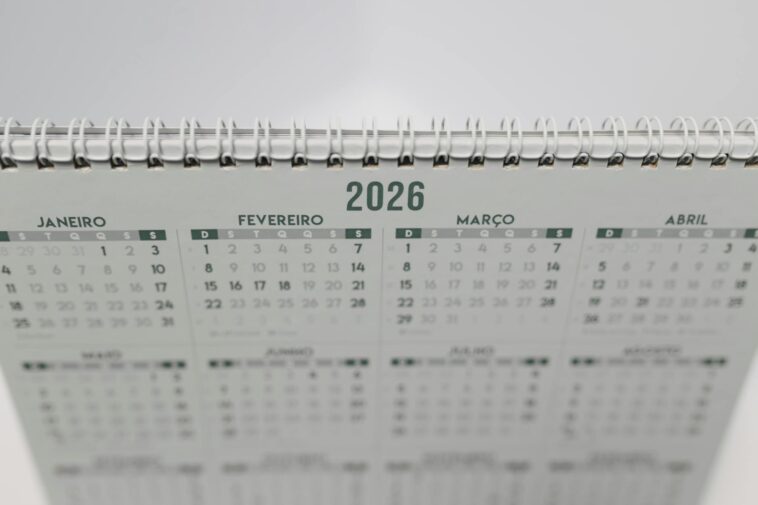 Close-up of a 2026 spiral-bound desk calendar with months in Portuguese.
