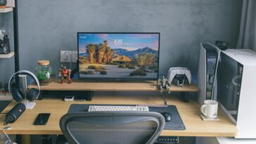 A contemporary home office desk featuring a computer setup with gaming peripherals and decor.