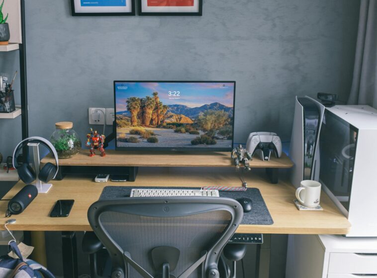 A contemporary home office desk featuring a computer setup with gaming peripherals and decor.