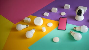 A vibrant display of smart home devices including bulbs, sensors, and a smartphone on a colorful background.