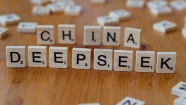 Close-up of wooden Scrabble tiles spelling 'China' and 'Deepseek' on a wooden surface.