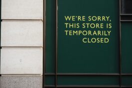 A photo of a store facade with a sign indicating temporary closure due to unforeseen circumstances.