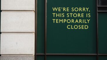 A photo of a store facade with a sign indicating temporary closure due to unforeseen circumstances.