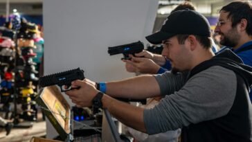 Group of men engaged in an indoor shooting game in Zagreb, showcasing hobby and leisure.