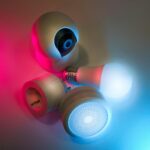 Smart home devices including camera, sensor, and bulb with ambient neon lighting. Ideal for tech concepts.