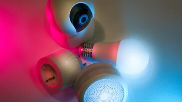 Smart home devices including camera, sensor, and bulb with ambient neon lighting. Ideal for tech concepts.