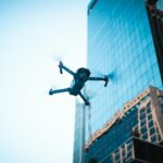 High-tech drone operating near a modern skyscraper captures urban technology in action.