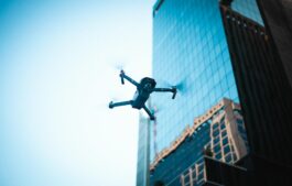 High-tech drone operating near a modern skyscraper captures urban technology in action.
