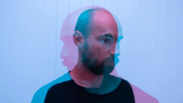 Through glass double exposure view of dreamy middle aged bearded male looking away on white background