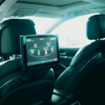 Spacious car interior featuring dual rear entertainment screens for backseat passengers.