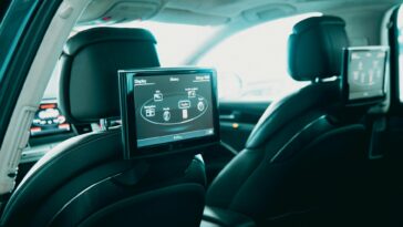 Spacious car interior featuring dual rear entertainment screens for backseat passengers.