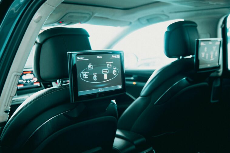 Spacious car interior featuring dual rear entertainment screens for backseat passengers.