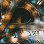 Top-down view of a city intersection with traffic and infrastructure at night.