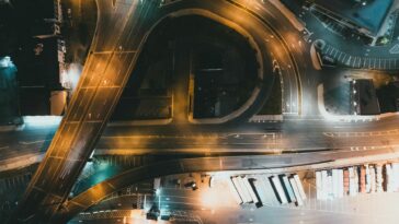 Top-down view of a city intersection with traffic and infrastructure at night.