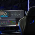Curved monitor displaying video editing software in a tech-savvy workspace with mood lighting.
