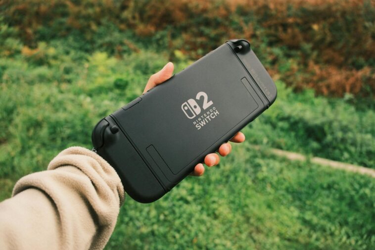 Person holding a Nintendo Switch in a natural outdoor setting, perfect for on-the-go gaming.