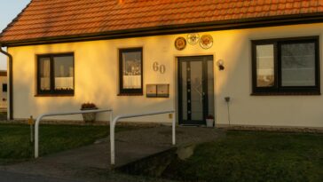 A well-lit, picturesque entrance of a modern home in Achim, Germany during sunset.