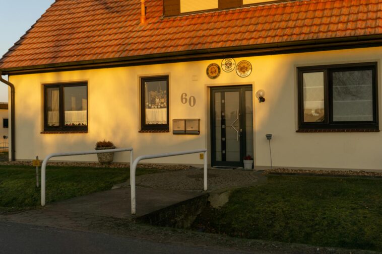 A well-lit, picturesque entrance of a modern home in Achim, Germany during sunset.