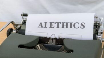 Close-up of vintage typewriter with 'AI ETHICS' typed on paper, emphasizing technology and responsibility.