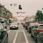 Long line of cars forming a heavy traffic jam in a bustling city center, showcasing urban congestion.