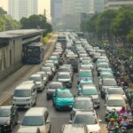 Dense traffic jam with buses and cars in a bustling city street during the day.