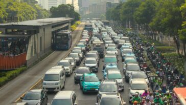 Dense traffic jam with buses and cars in a bustling city street during the day.