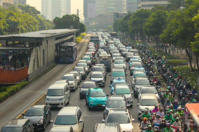 Dense traffic jam with buses and cars in a bustling city street during the day.